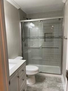 bathroom featuring crown molding, vanity, toilet, and an enclosed shower