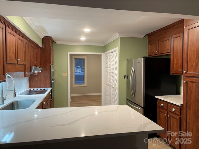 kitchen with ornamental molding, stainless steel appliances, light stone countertops, and sink