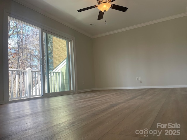 spare room with visible vents, crown molding, baseboards, and wood finished floors