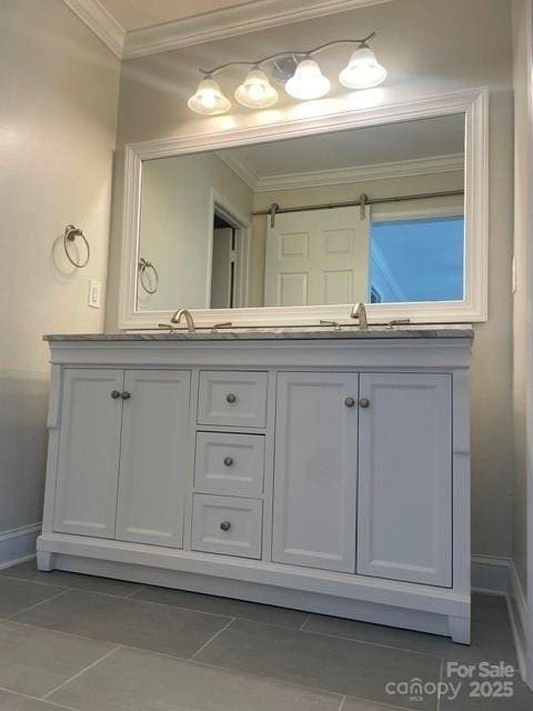 full bath featuring a sink, double vanity, baseboards, and ornamental molding