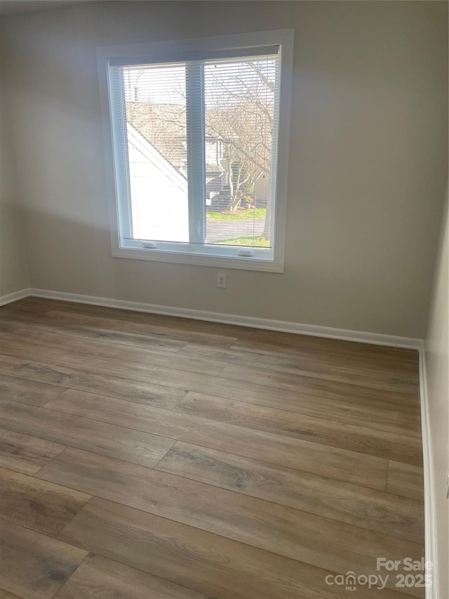 unfurnished room featuring wood finished floors and baseboards