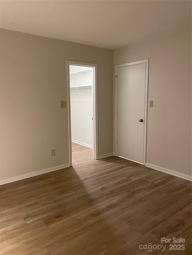 unfurnished room with baseboards and wood finished floors