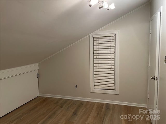 bonus room with baseboards, wood finished floors, and vaulted ceiling