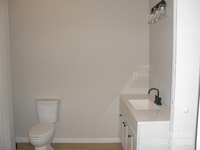 bathroom with vanity, toilet, and wood-type flooring