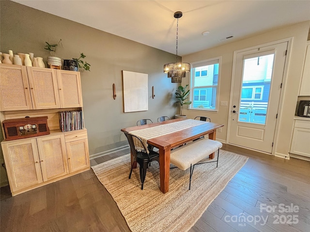 dining space featuring dark hardwood / wood-style floors and a notable chandelier