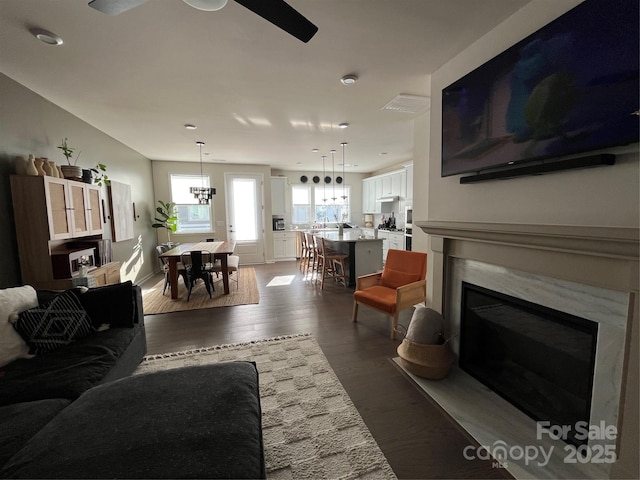 living room featuring hardwood / wood-style flooring, ceiling fan, and a fireplace