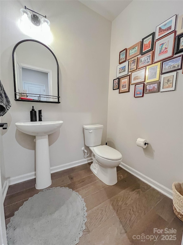 bathroom with toilet and hardwood / wood-style floors