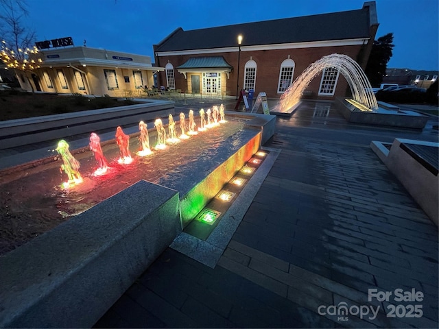 pool at twilight featuring an outdoor fire pit