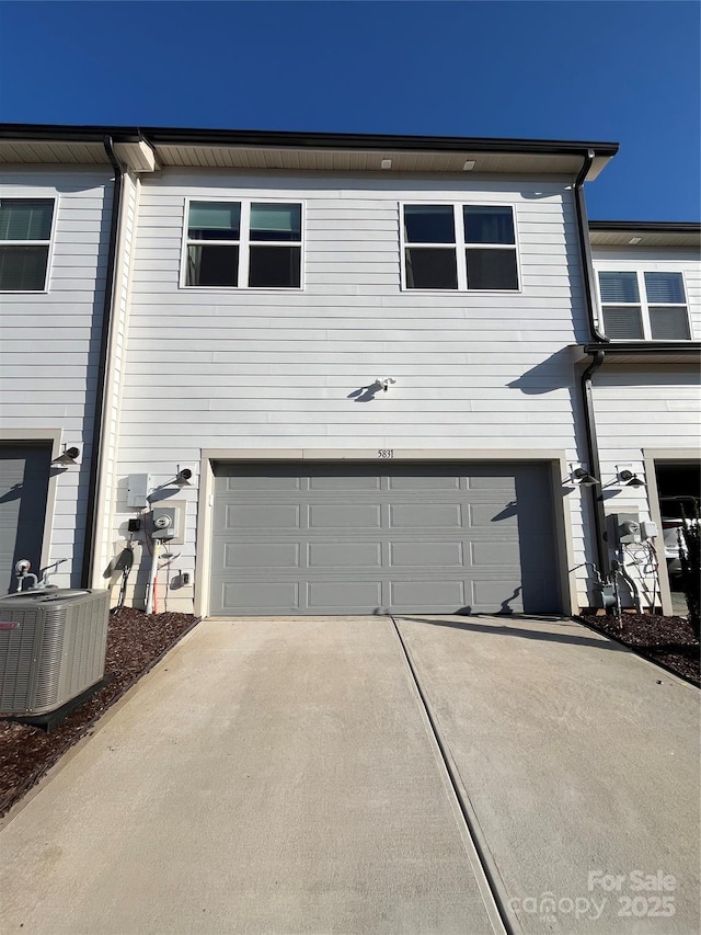 view of front facade featuring a garage and central AC unit