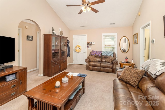 living room with ceiling fan, vaulted ceiling, and light carpet