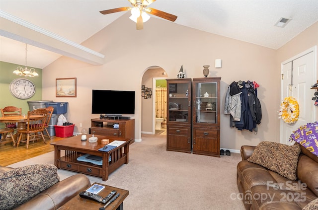 carpeted living room featuring lofted ceiling and ceiling fan with notable chandelier