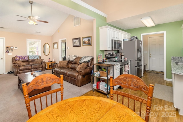 living room featuring vaulted ceiling, light wood-type flooring, and ceiling fan