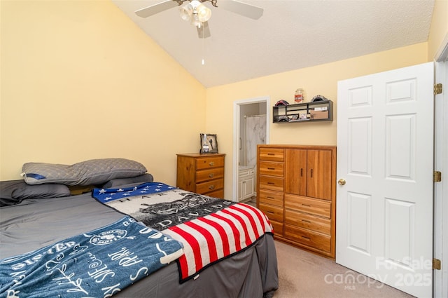 carpeted bedroom featuring ceiling fan, ensuite bathroom, and vaulted ceiling