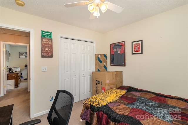 bedroom with ceiling fan, light colored carpet, a textured ceiling, and a closet