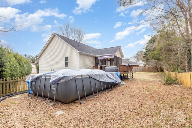 rear view of property featuring a covered pool