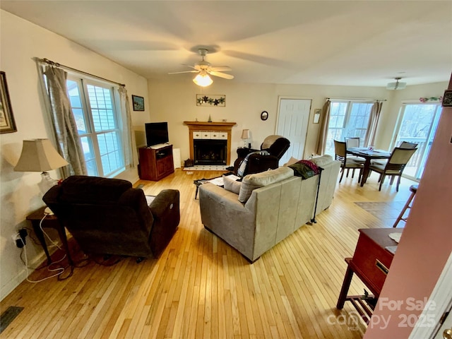 living room with light hardwood / wood-style flooring and ceiling fan