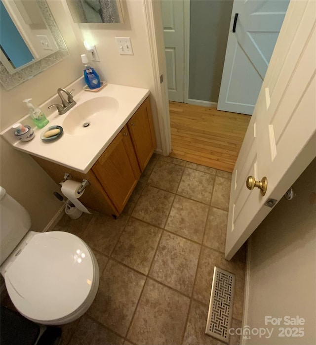 bathroom featuring vanity, tile patterned flooring, and toilet