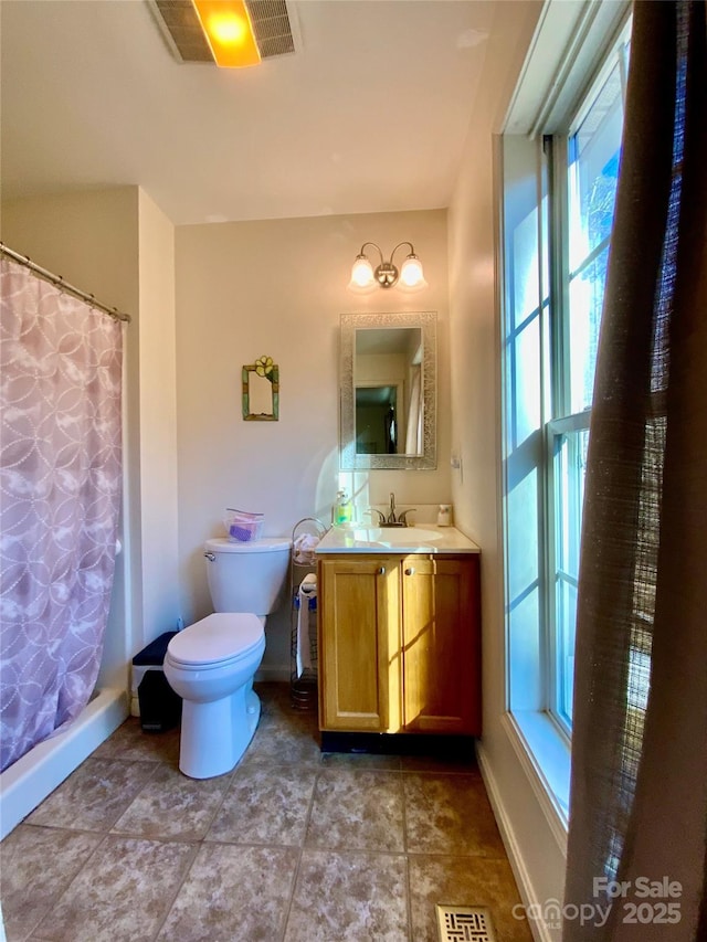 bathroom featuring vanity, toilet, and walk in shower