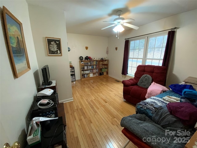 living room featuring hardwood / wood-style floors and ceiling fan