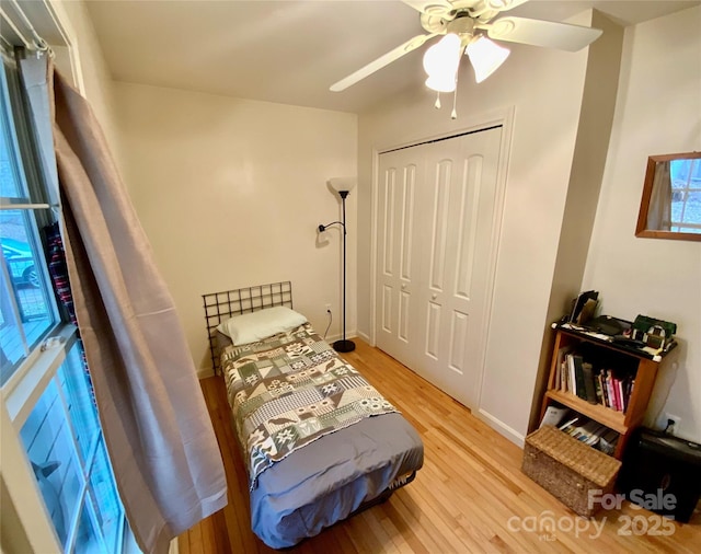 bedroom with ceiling fan, light wood-type flooring, and a closet