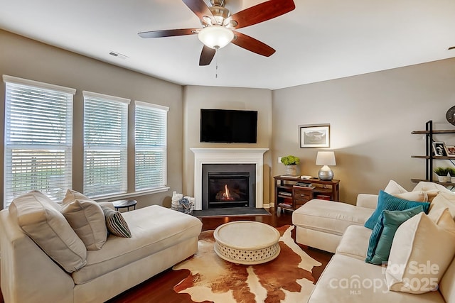 living room with dark hardwood / wood-style flooring and ceiling fan