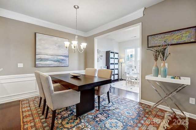 dining room featuring hardwood / wood-style floors, crown molding, and a notable chandelier