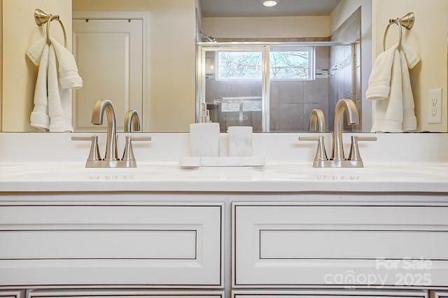 bathroom featuring a shower with door and vanity