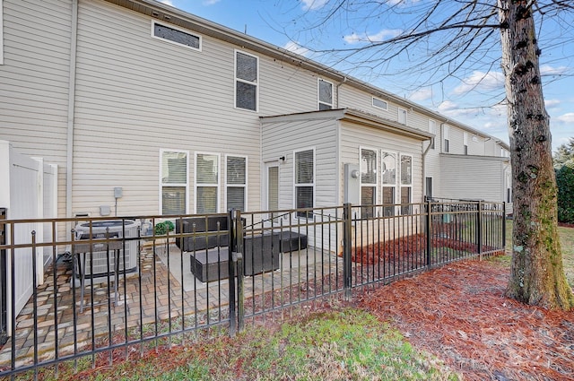 rear view of house with central AC and a patio area