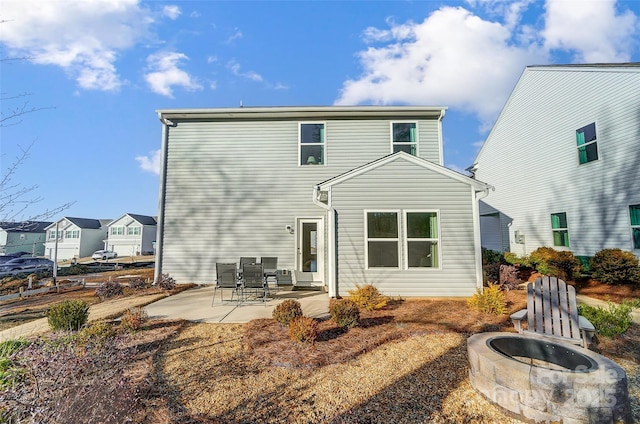 back of house with a patio and a fire pit