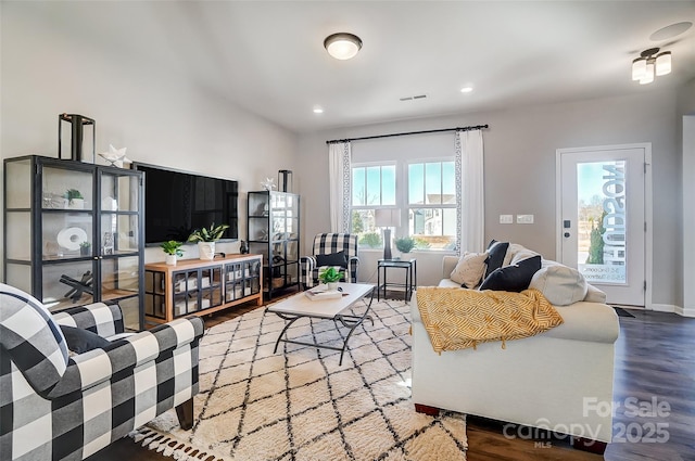 living room featuring visible vents, baseboards, wood finished floors, and recessed lighting