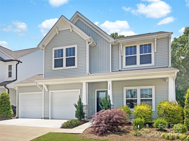 128 Shay Crossing Rd, Salisbury, NC 28146 - view of front of home featuring concrete driveway, a porch, board and batten siding, and an attached garage