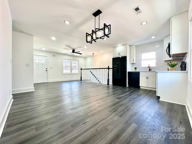 kitchen with white cabinetry, sink, dark wood-type flooring, and black appliances