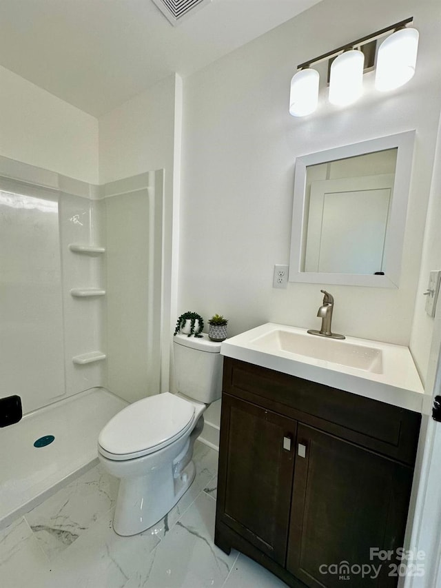 bathroom with vanity, toilet, and a shower