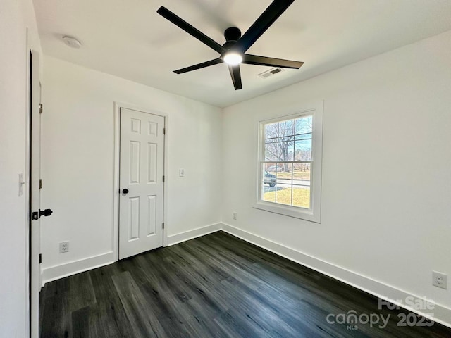 spare room with ceiling fan and dark hardwood / wood-style flooring