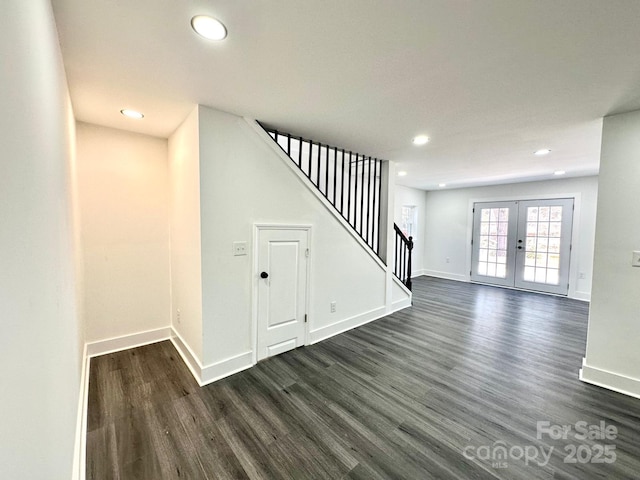 unfurnished living room with dark hardwood / wood-style flooring and french doors