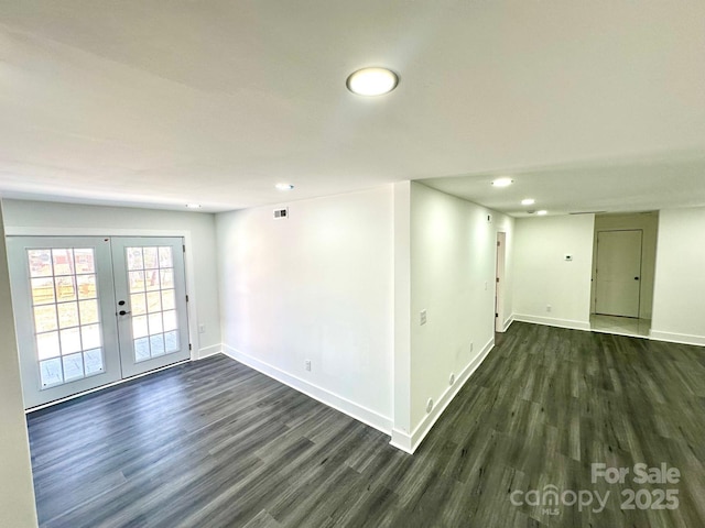 empty room featuring dark hardwood / wood-style flooring and french doors