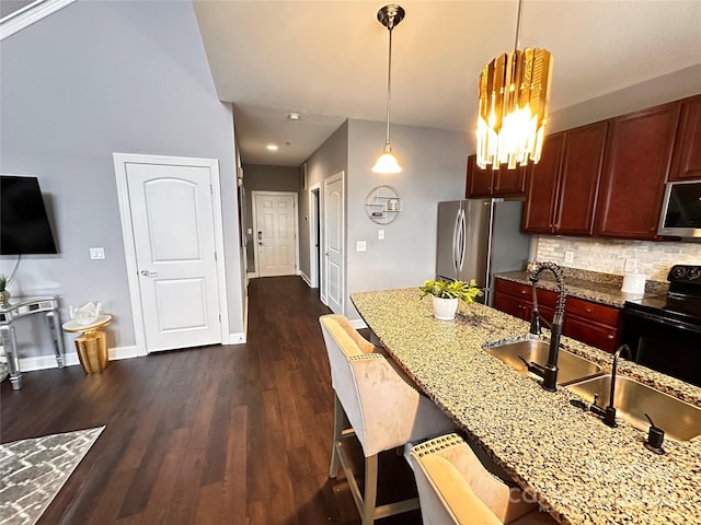 kitchen with light stone countertops, pendant lighting, a breakfast bar area, and appliances with stainless steel finishes