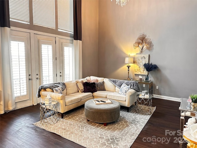 living area with a healthy amount of sunlight, dark wood finished floors, and baseboards