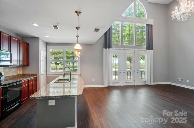 128 Steinbeck Way Unit E, Mooresville, NC 28117 - kitchen with a sink, a wealth of natural light, black electric range oven, and reddish brown cabinets