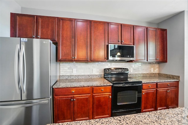 128 Steinbeck Way Unit E, Mooresville, NC 28117 - kitchen with appliances with stainless steel finishes, decorative backsplash, light stone counters, and reddish brown cabinets