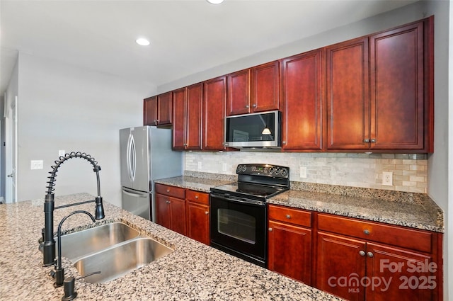 128 Steinbeck Way Unit E, Mooresville, NC 28117 - kitchen featuring light stone countertops, reddish brown cabinets, tasteful backsplash, a sink, and stainless steel appliances