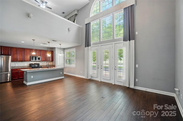128 Steinbeck Way Unit E, Mooresville, NC 28117 - living area featuring baseboards, ceiling fan, dark wood-type flooring, and a towering ceiling
