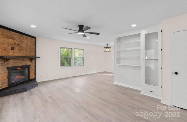 unfurnished living room featuring ceiling fan, a fireplace, and light wood-type flooring