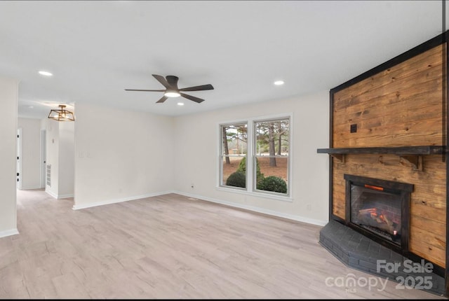 unfurnished living room featuring ceiling fan and light wood-type flooring