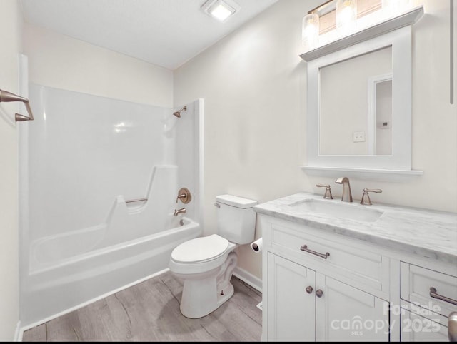 full bathroom with hardwood / wood-style flooring, washtub / shower combination, vanity, and toilet