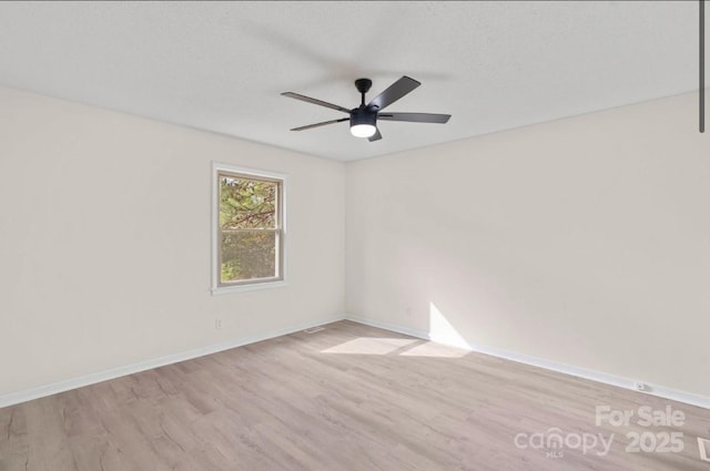 empty room with a textured ceiling, light hardwood / wood-style flooring, and ceiling fan