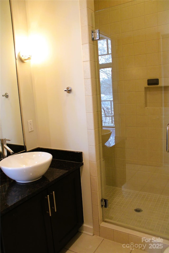 bathroom with tile patterned flooring, sink, and a shower with shower door