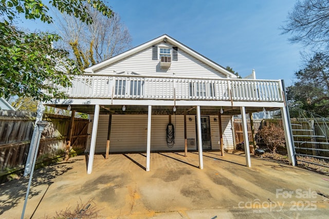 rear view of property with a wooden deck and a patio