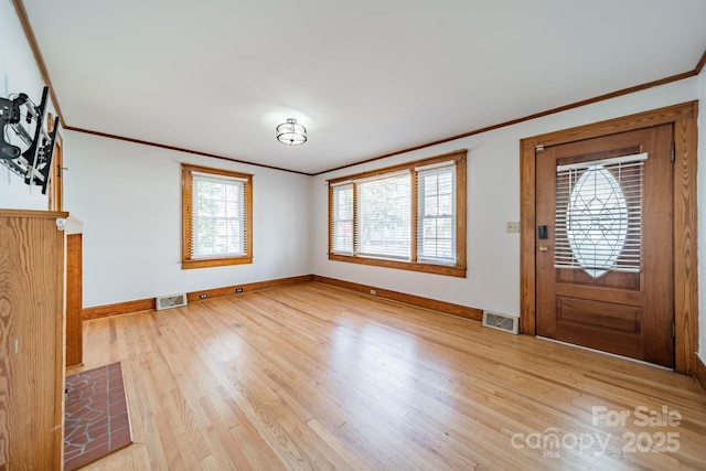 entrance foyer featuring ornamental molding and light wood-type flooring