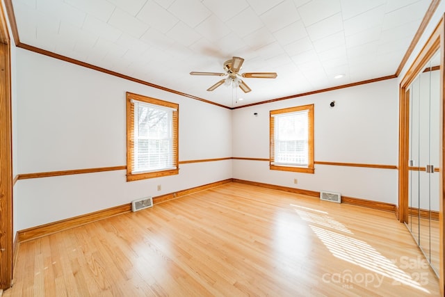 empty room featuring ceiling fan, ornamental molding, plenty of natural light, and light hardwood / wood-style floors